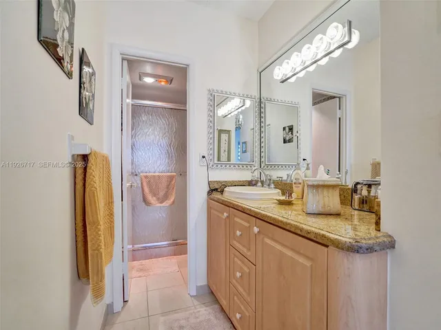 a bathroom with a granite countertop sink and a mirror
