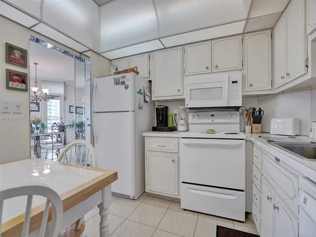 a kitchen with white cabinets and white appliances