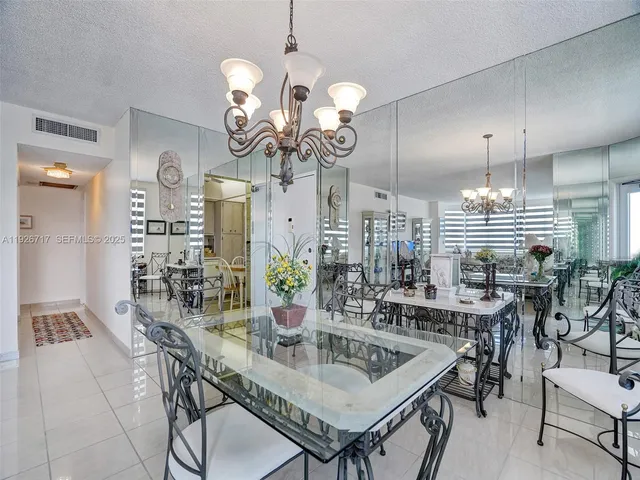 a very nice looking dining room with a table chairs and chandelier