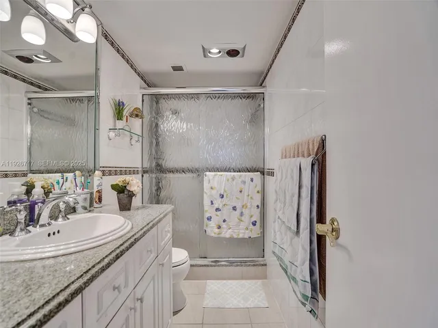 a bathroom with a granite countertop sink a shower and a mirror