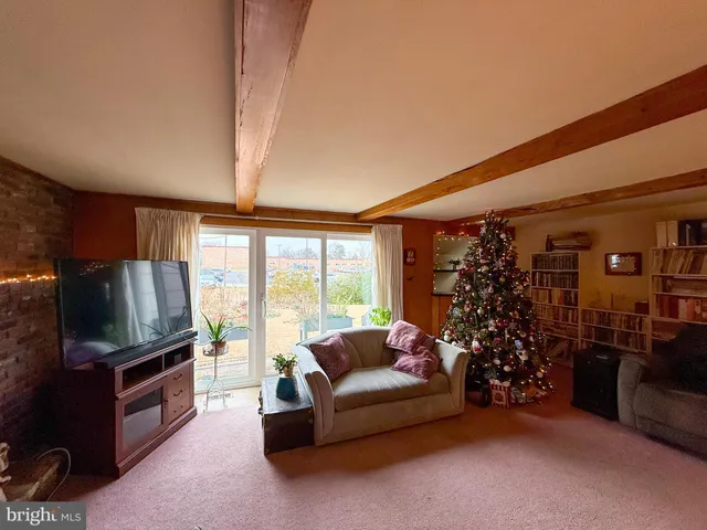 a living room with furniture a flat screen tv and a floor to ceiling window