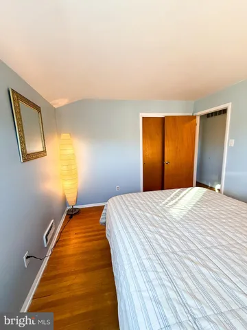 a bedroom with a bed and wooden floor