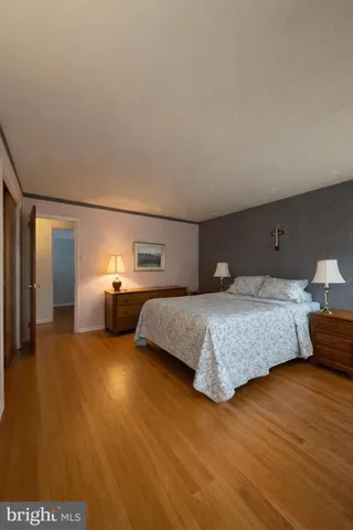 a bedroom with a bed and wooden floor