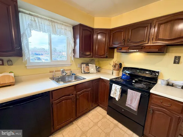 a kitchen with a sink stove top oven and cabinets