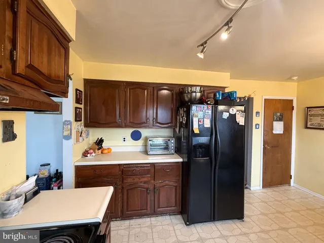 a kitchen with a sink a refrigerator and cabinets