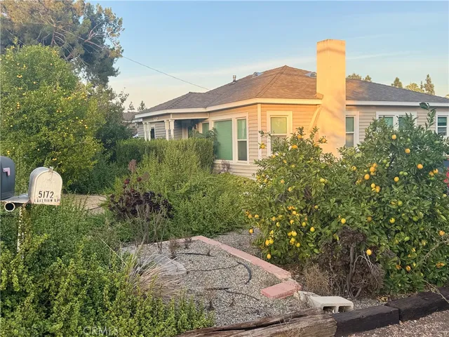 a front view of a house with a yard and trees