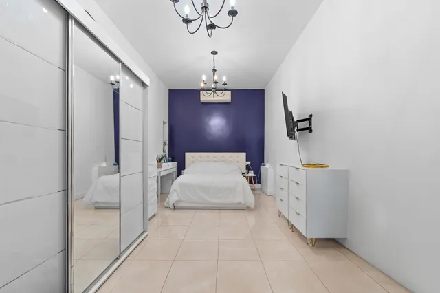 a spacious bedroom with a bed and a chandelier