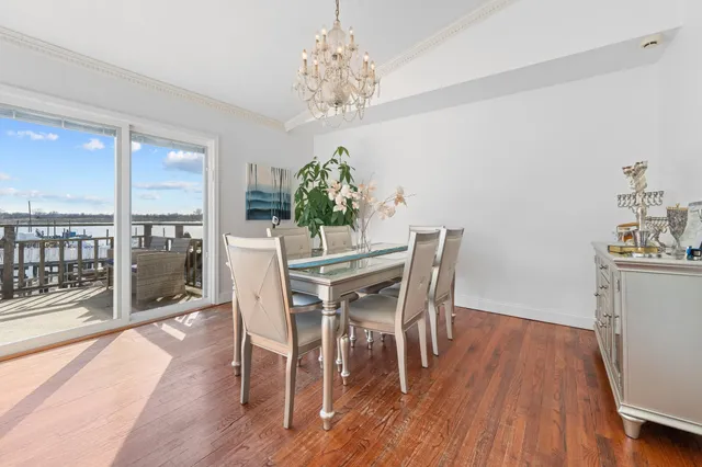 a dining room with furniture wooden floor a potted plant and a chandelier