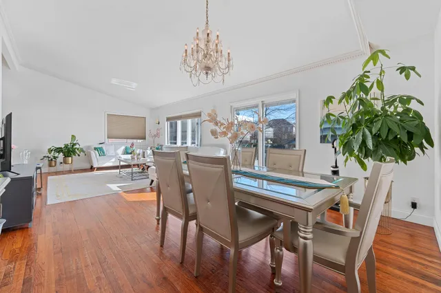 a dining room with furniture potted plants and wooden floor