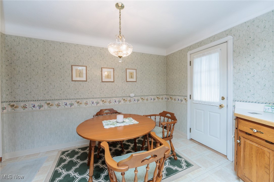 6192 Stanbury Road Parma, OH 44129 - Photo 22 of 49 Dining area featuring wallpapered walls, light floors, and a chandelier