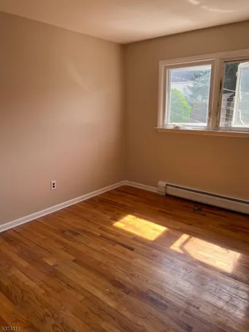 a view of a room with wooden floor and small window