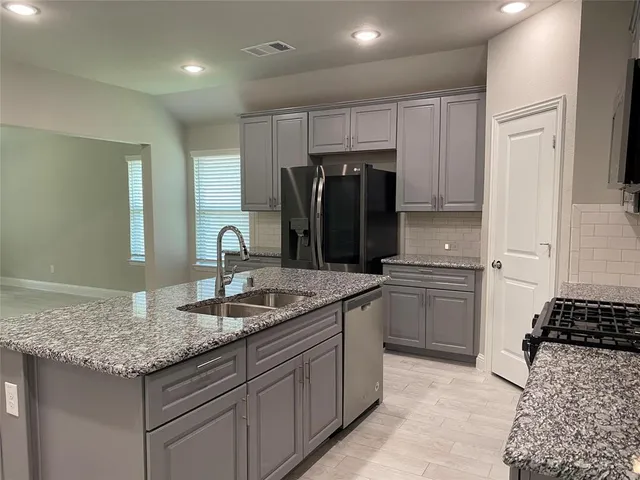 a kitchen with stainless steel appliances granite countertop a sink stove and refrigerator