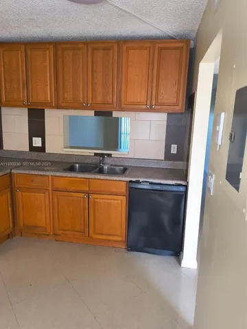 a kitchen with granite countertop a stove top oven sink and cabinets