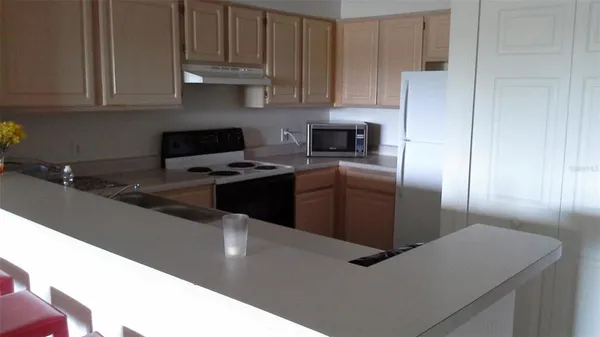 a kitchen with stainless steel appliances granite countertop a sink a stove and a refrigerator