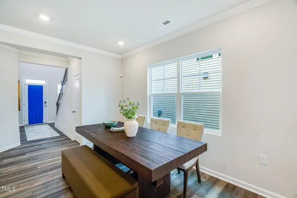 a kitchen with stainless steel appliances granite countertop a white refrigerator a sink a stove a dining table and chairs