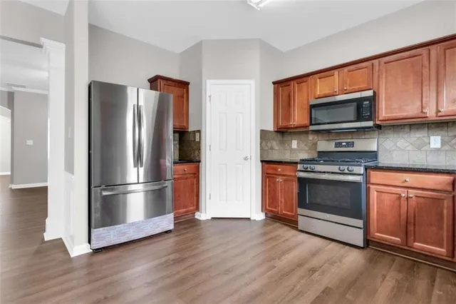 a kitchen with wooden floors and stainless steel appliances