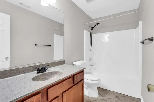 a bathroom with a granite countertop sink toilet a mirror and shower