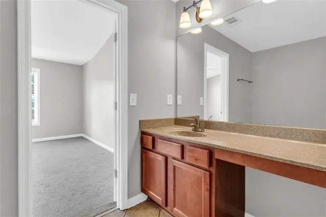 a bathroom with a granite countertop sink and a mirror