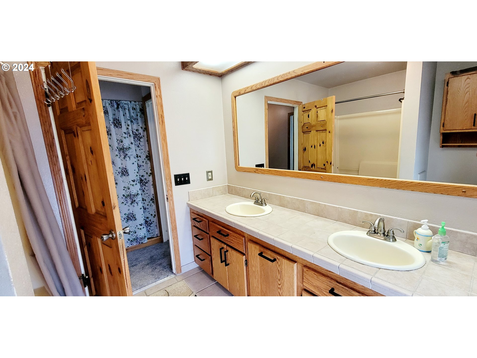 611 East 3rd Avenue Riddle, OR 97469 - Photo 26 of 42 a bathroom with a sink a mirror a vanity and a shower