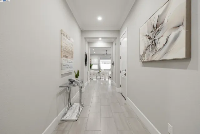 a view of a hallway with wooden floor and a bathroom