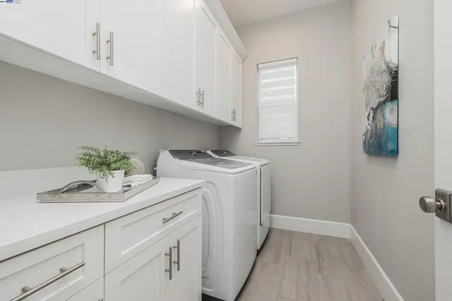 a utility room with cabinets washer and dryer