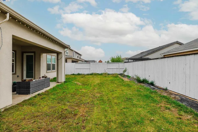 a view of backyard with barbeque grill and potted plants