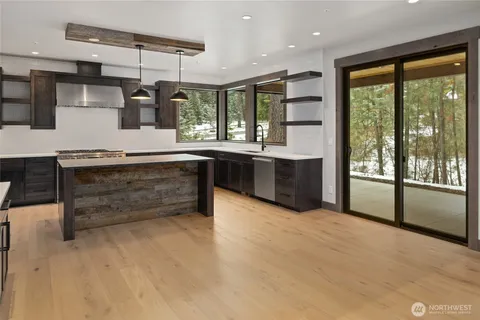a large kitchen with a large window and stainless steel appliances