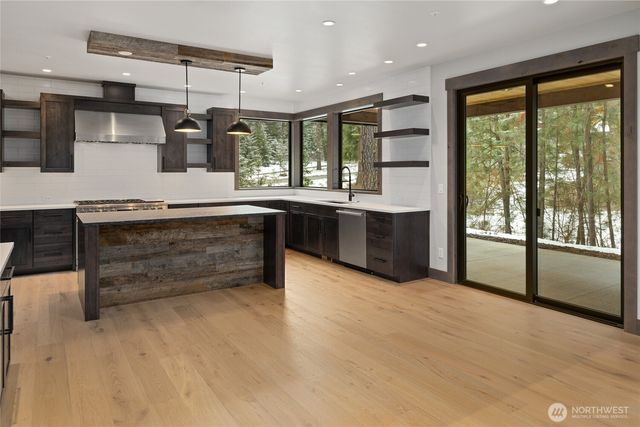 a large kitchen with a large window and stainless steel appliances