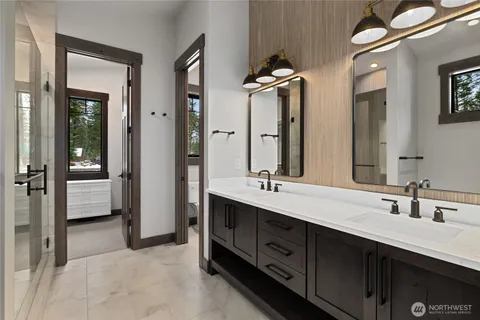 a spacious bathroom with a double vanity sink double mirror and bathtub