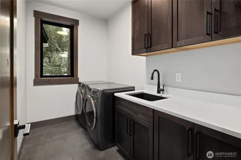 a utility room with sink washer and dryer