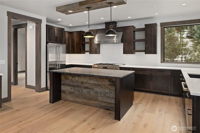 a kitchen with stainless steel appliances granite countertop a sink a stove and a refrigerator