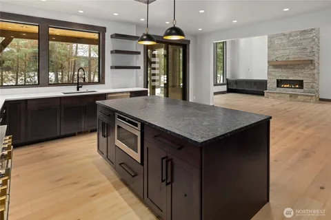 a kitchen with a sink a counter top space stainless steel appliances and a large window
