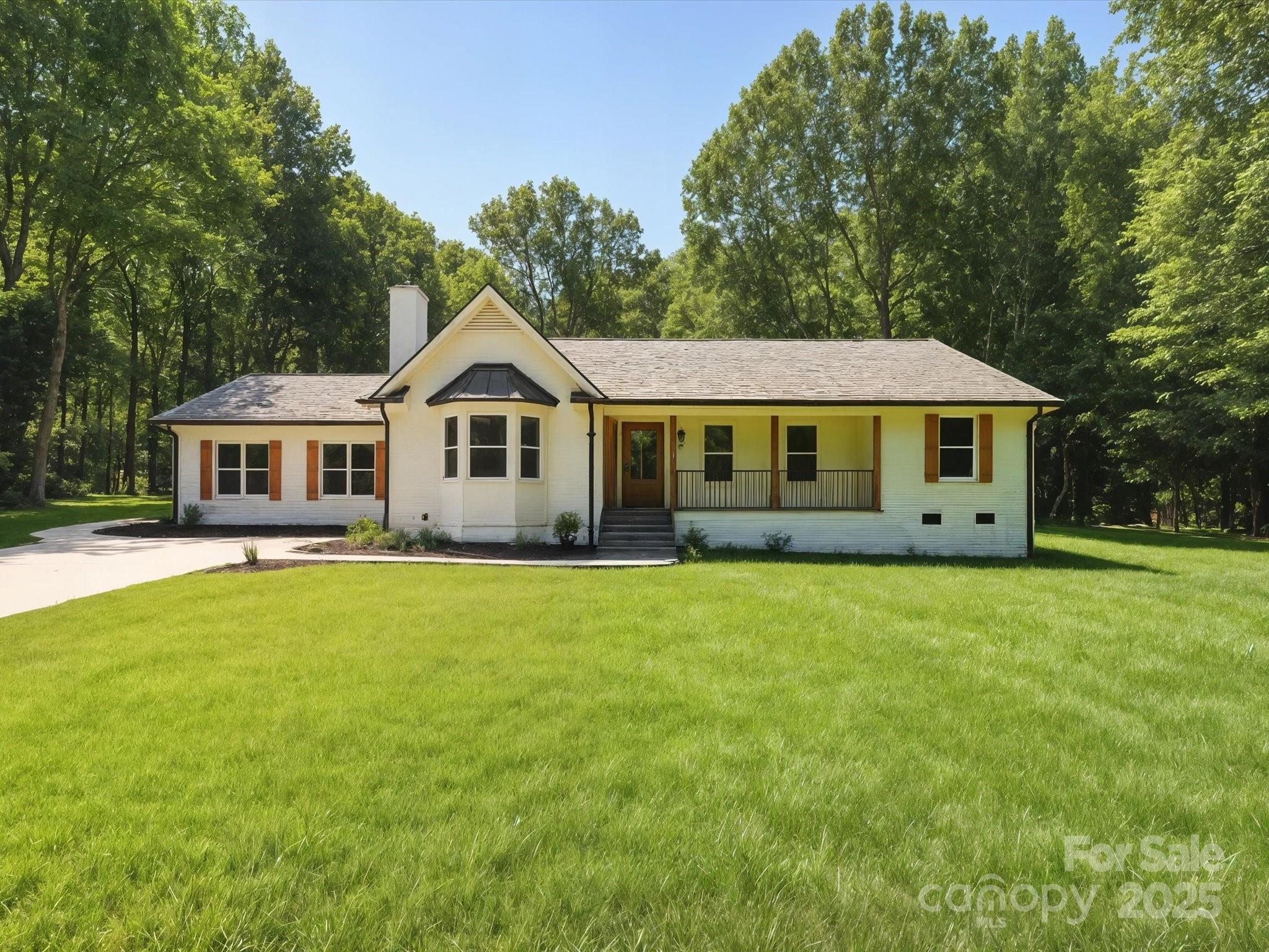 a view of a big house with a big yard and large trees