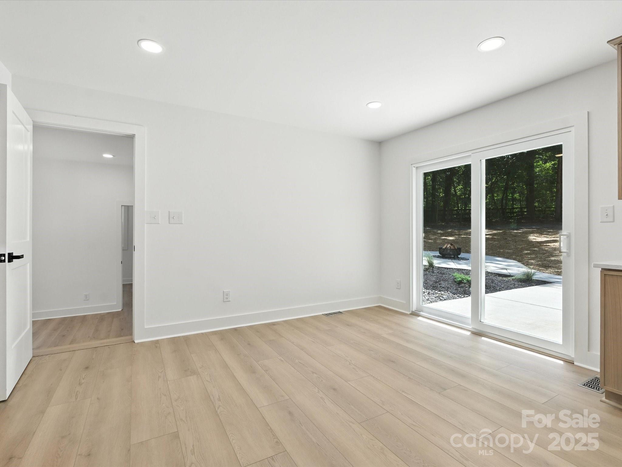 3303 Reid Circle Monroe, NC 28112 - Photo 12 of 44 an empty room with wooden floor and windows