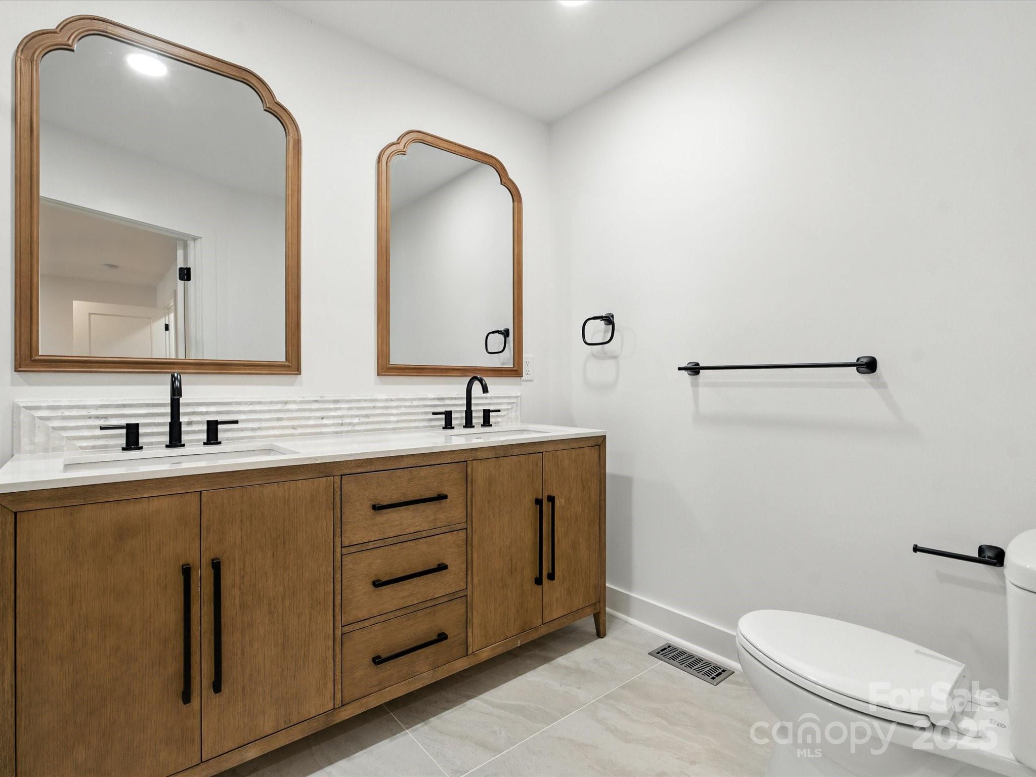 3303 Reid Circle Monroe, NC 28112 - Photo 19 of 44 a bathroom with a toilet a sink and mirror