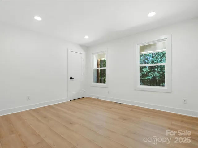 an empty room with wooden floor and window