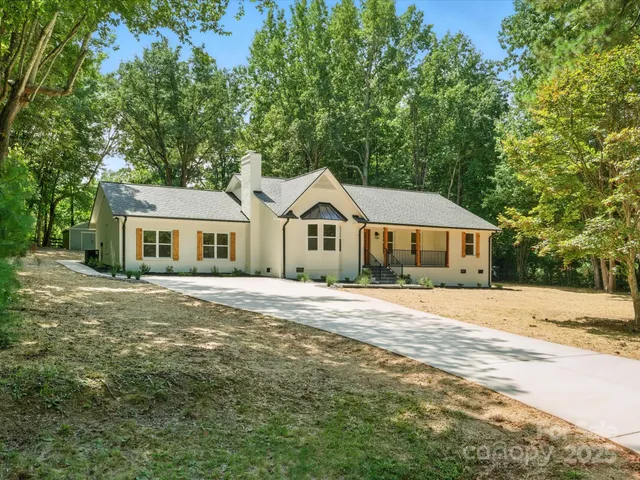 a front view of a house with a yard and trees