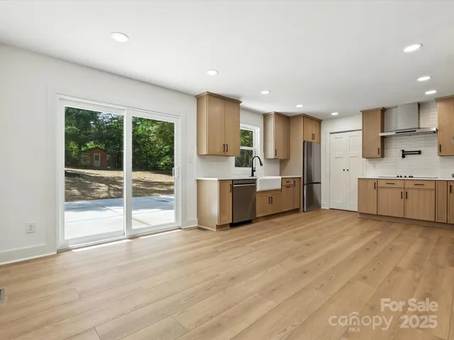 a kitchen with stainless steel appliances a refrigerator sink and cabinets