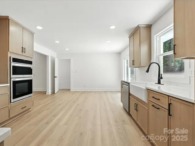 a kitchen with stainless steel appliances a sink cabinets and wooden floor