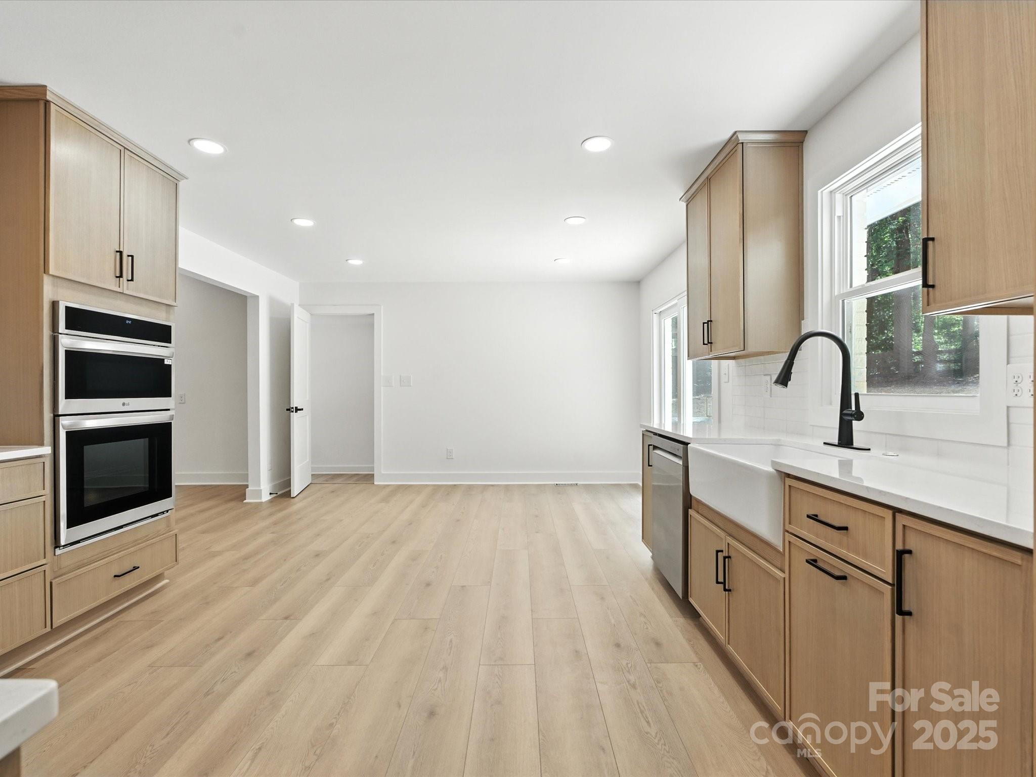 3303 Reid Circle Monroe, NC 28112 - Photo 9 of 44 a kitchen with stainless steel appliances a sink cabinets and wooden floor