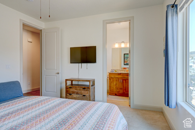1329 Paseos Street Washington, UT 84780 - Photo 10 of 35 Bedroom with multiple windows, light carpet, and ensuite bathroom