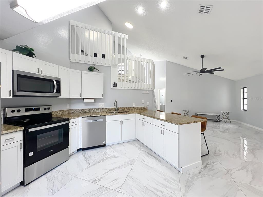 622 Anhinga Road Winter Springs, FL 32708 - Photo 13 of 53 a kitchen with granite countertop a sink a stove and cabinets