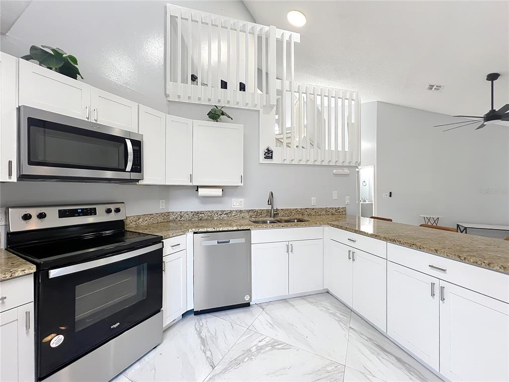 622 Anhinga Road Winter Springs, FL 32708 - Photo 15 of 53 a kitchen with granite countertop a stove a sink and a microwave