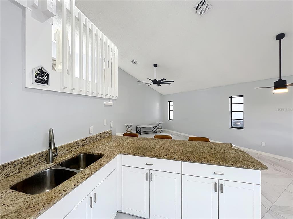 622 Anhinga Road Winter Springs, FL 32708 - Photo 16 of 53 a kitchen with granite countertop a sink a stove and cabinets