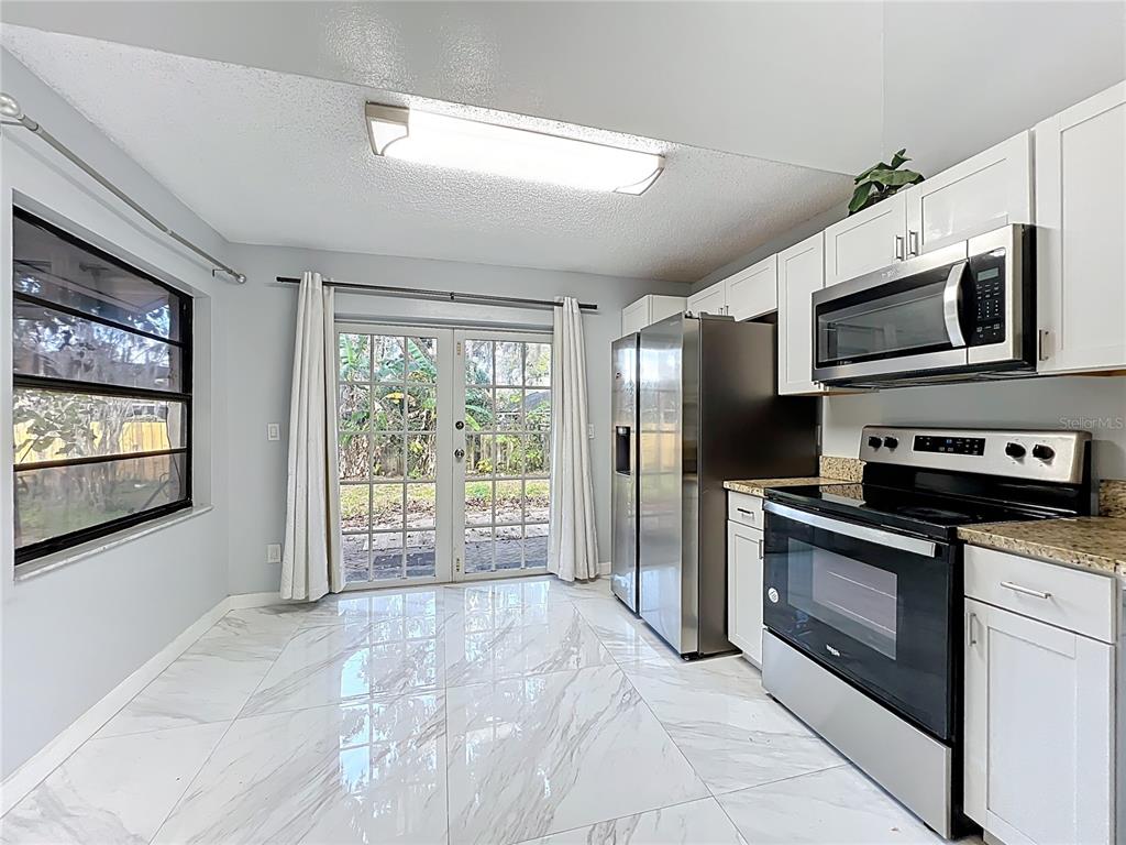 622 Anhinga Road Winter Springs, FL 32708 - Photo 17 of 53 a kitchen with stainless steel appliances a stove sink and microwave