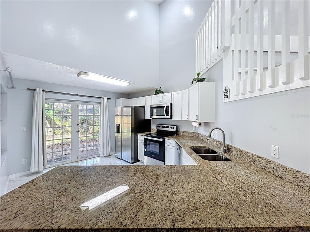 622 Anhinga Road Winter Springs, FL 32708 - Photo 18 of 53 a kitchen with stainless steel appliances granite countertop a stove a sink and a refrigerator