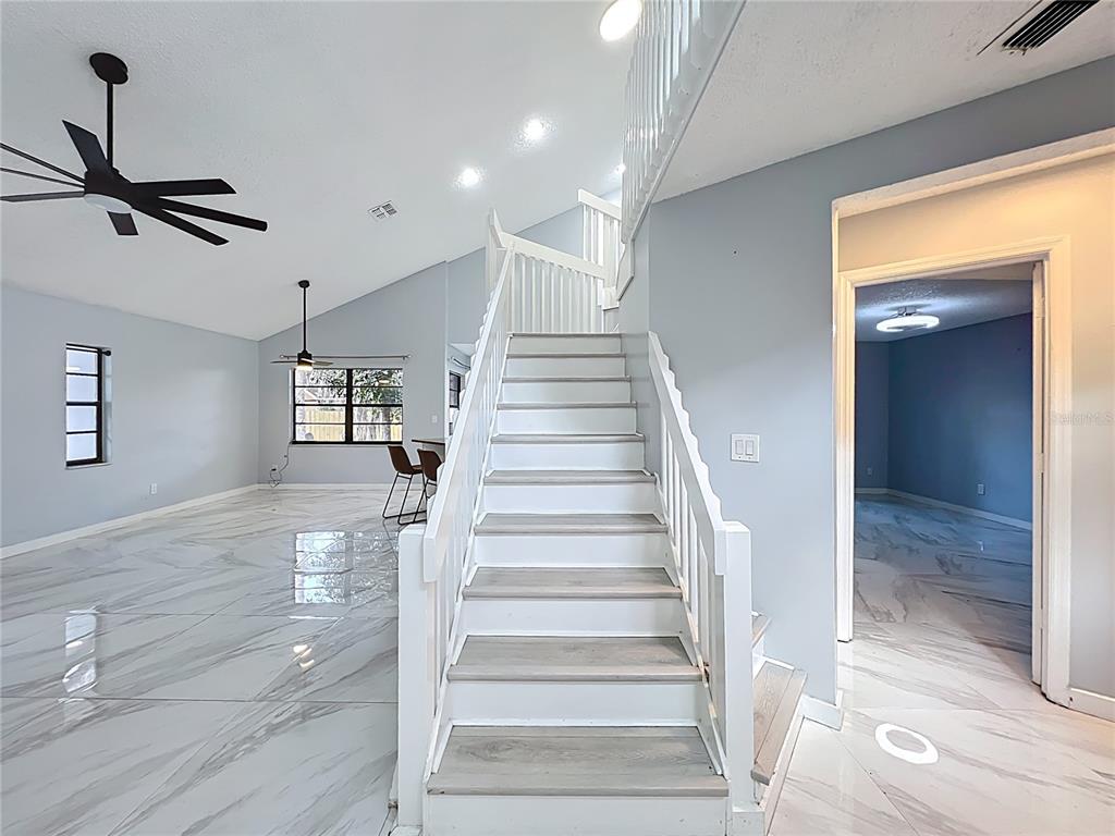 622 Anhinga Road Winter Springs, FL 32708 - Photo 6 of 53 a view of staircase with white walls and wooden floor