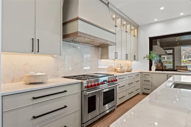 a kitchen with stainless steel appliances white cabinets and a stove top oven