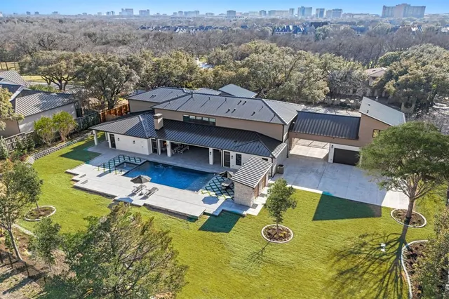 a view of a house with a big yard and large trees
