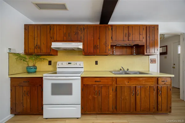 a kitchen with granite countertop wooden cabinets and white appliances